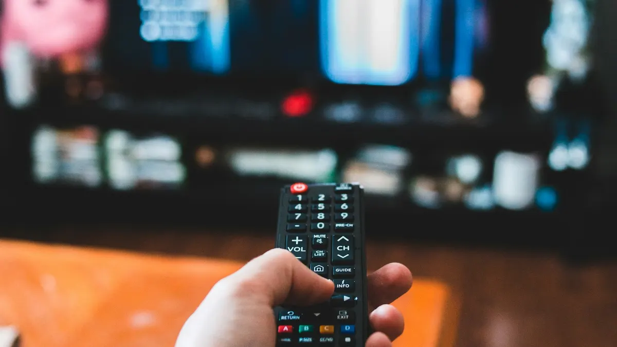 Person gibt einen Aktivierungscode auf einem Smart-TV-Bildschirm ein